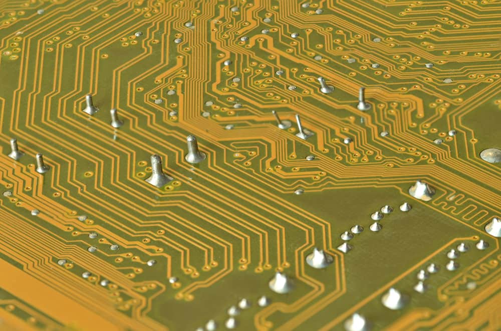 柔性 PCB 焊接缺陷的特写，包括冷接点和桥接。