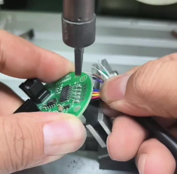 Desoldering through-hole component with a desoldering wick on a PCB